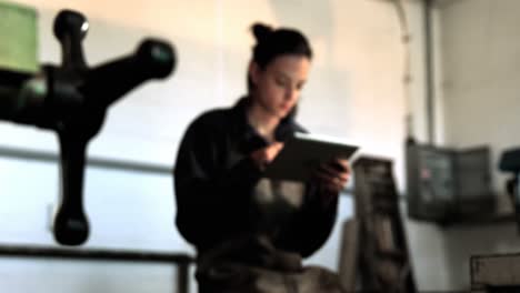 Female-welder-using-digital-tablet