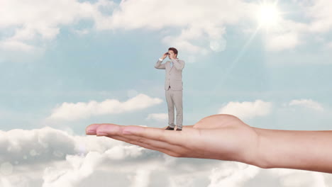 Hand-holding-standing-businessman-with-binoculars-against-blue-sky