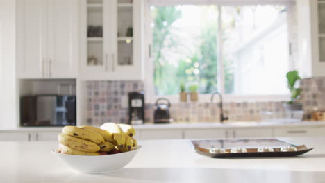 Close-up-of-bowl-of-bananas-lying-on-table-in-kitchen