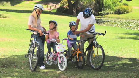 Young-couple-with-their-two-children-ready-to-go-cycling