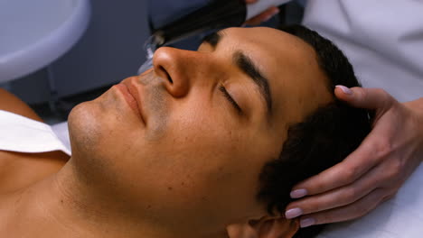 Doctor-performing-laser-hair-removal-on-patient-face