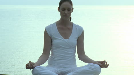 Frau-Macht-Yoga-Mit-Meer-Im-Hintergrund