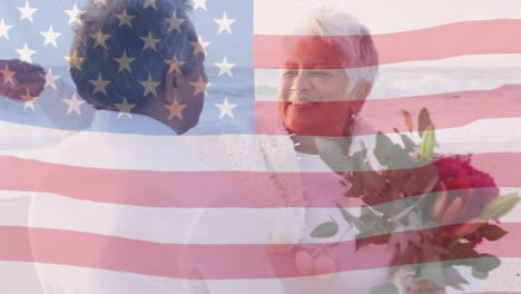 Animation-Der-Flagge-Der-Vereinigten-Staaten-Von-Amerika-über-Einem-älteren-Gemischtrassigen-Paar,-Das-Sich-Am-Strand-Umarmt
