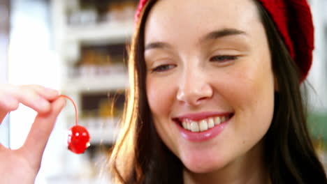 Smiling-woman-holding-a-cherry
