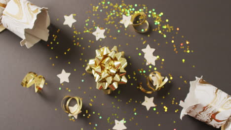 Video-of-christmas-crackers,-stars-and-decoration-on-grey-background