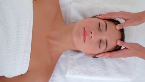 Attractive-young-woman-receiving-head-massage-at-spa-center