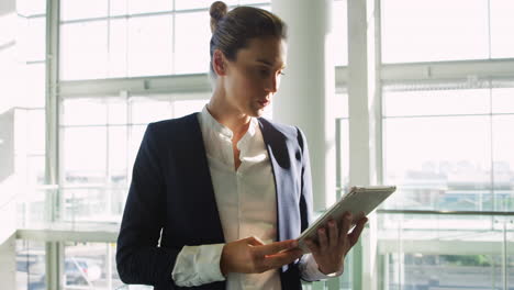 Businesswoman-using-tablet-in-modern-office-building