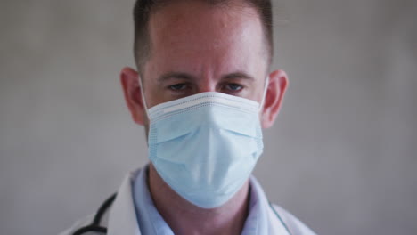 Portrait-of-caucasian-male-doctor-wearing-face-mask