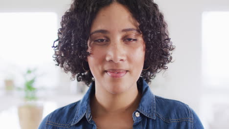 Portrait-of-biracial-woman-looking-to-camera-and-smiling,-in-slow-motion