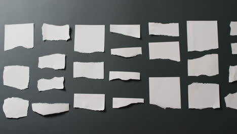 Video-of-close-up-of-multiple-torn-piece-of-white-paper-with-copy-space-on-black-background