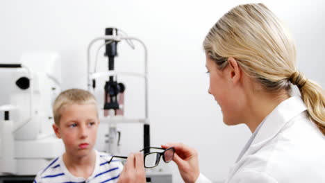 Optometrista-Femenina-Recetando-Gafas-A-Un-Paciente-Joven