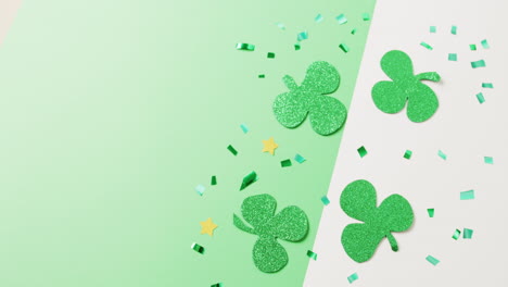 Video-of-st-patrick's-green-shamrock-leaves-with-copy-space-on-green-to-white-background