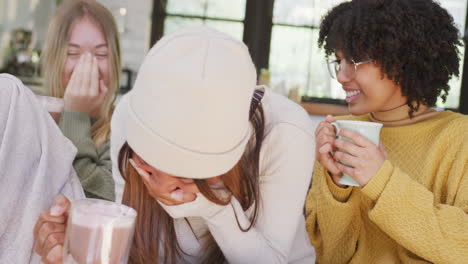 Happy-diverse-teenager-girls-friends-drinking-coffee-and-laughing-at-home,-slow-motion
