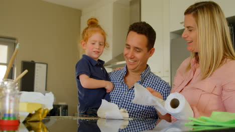 Parents-teaching-their-son-to-clean-kitchen-worktop-4k