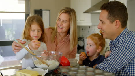 Parents-teaching-their-daughter-to-break-the-egg-while-baking-4k