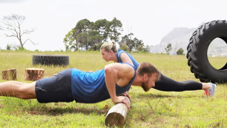 Fit-man-and-woman-doing-pushup-during-obstacle-course