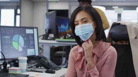 Woman-wearing-face-mask-sitting-on-her-desk-at-home