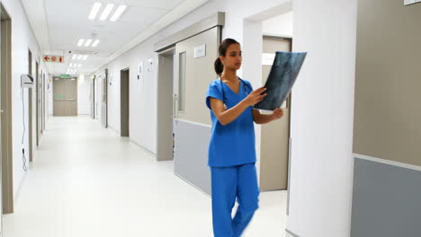 Female-doctor-examining-x-ray-in-corridor