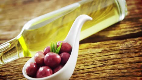 Olive-oil-bottle-and-spoon-full-of-red-olives