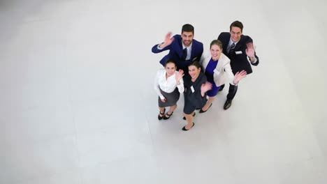 Smiling-businesspeople-waving-hands-in-office