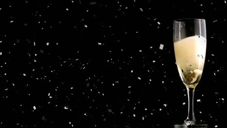 Animation-of-confetti-falling-and-glass-of-champagne-on-black-background