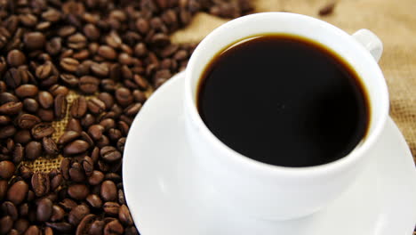 Kaffeetasse-Und-Geröstete-Bohnen-Auf-Sacktextilien