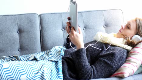 Beautiful-woman-using-digital-tablet-in-living-room