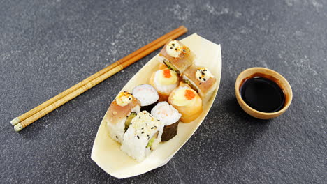 Sushi-Auf-Einem-Bootförmigen-Teller-Mit-Stäbchen