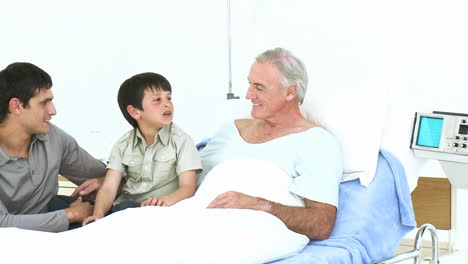 Man-and-kid-visiting-a-senior-man-recovering-in-hospital