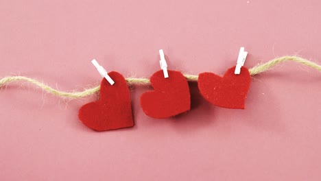 Red-hearts-with-cloth-peg-hanging-on-rope