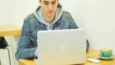 Man-using-laptop-while-having-coffee