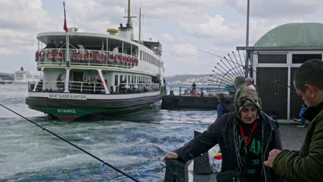 Fischer-Und-Frau-Unterhalten-Sich-Am-Eminönü-Pier,-Während-Die-öffentliche-Fähre-Den-Hafen-Verlässt