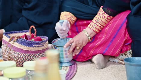 Una-Mujer-árabe-Pulverizando-Las-Especias-A-Mano-Usando-Una-Piedra-De-Forma-Tradicional.