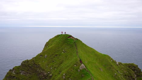 Photographers-on-mountain-top-against-Atlantic-Ocean-backdrop,-Faroe-Islands