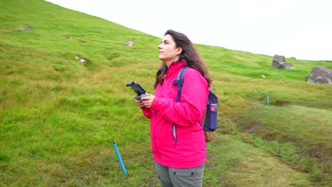 Female-pilot-plays-outdoor-with-new-drone,-Faroe-Islands