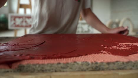 Close-Up-Shot-Of-Professional-Artisan-Spreading-Red-Tint-With-Trowel