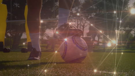 Glowing-network-of-connections-over-low-section-of-male-soccer-player-practicing-on-sports-field