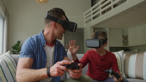 Caucasian-father-with-son-using-vr-headsets-and-sitting-in-living-room