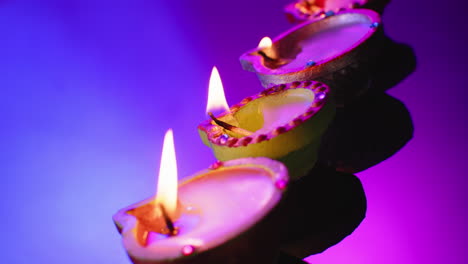 Nahaufnahme-Brennender-Kerzen-In-Reihe,-Die-Diwali-Auf-Blauem-Hintergrund-Feiern