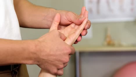Männlicher-Physiotherapeut,-Der-Einer-Patientin-Eine-Handmassage-Gibt