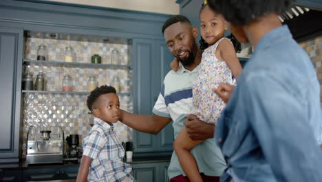 Happy-african-american-family-talking-and-cooking-in-kitchen,-in-slow-motion