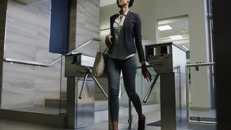 African-american-businesswomen-walking-through-a-turnstile-entering-an-office-in-slow-motion