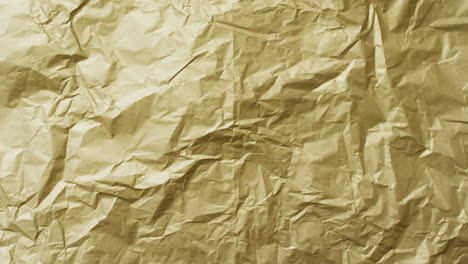 Video-of-close-up-of-crumpled-yellow-paper-texture-background