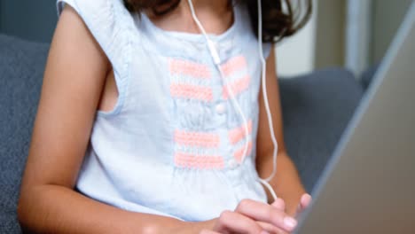 Mädchen-Mit-Kopfhörern-Und-Laptop-Im-Wohnzimmer