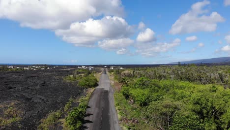 The-road-into-kalapana-lava-rock-community-with-jungle-and-cooled-lava