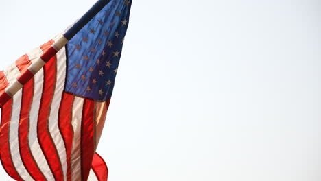 Slow-motion-shot-of-an-American-flag-flying-in-the-wind-on-a-flag-pole