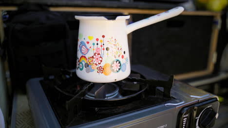 Blue-flame-gas-cooker-burner,-with-a-coffee-pot-preparing-the-morning-coffee