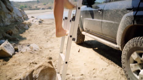 Bikini-swimwear,-swimsuit-wearing-woman-climbing-ladder-on-vacation-at-a-beach