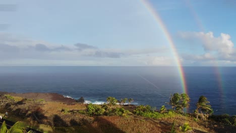 Zwei-Oder-Doppelte-Regenbogen-über-Dem-Pazifischen-Ozean-Mit-Klippen-Im-Vordergrund-Bei-Sonnenuntergang