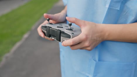 Close-up-of-young-female-hands-operating-drone-remote-controller
